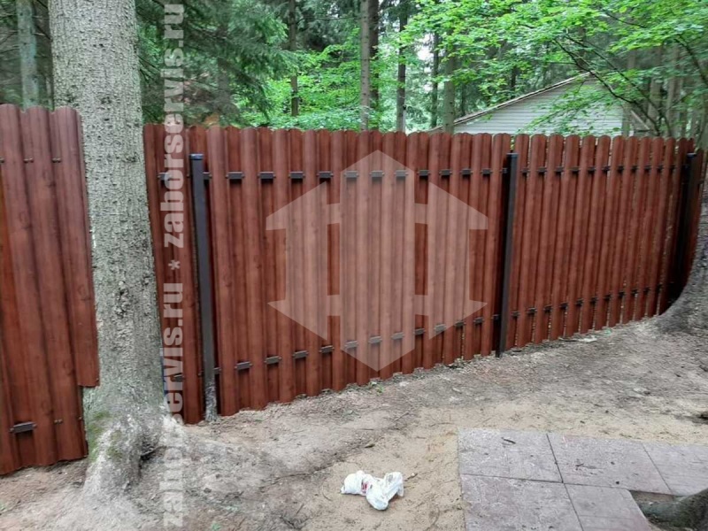 Забор из металлического штакетника на фундаменте под дерево