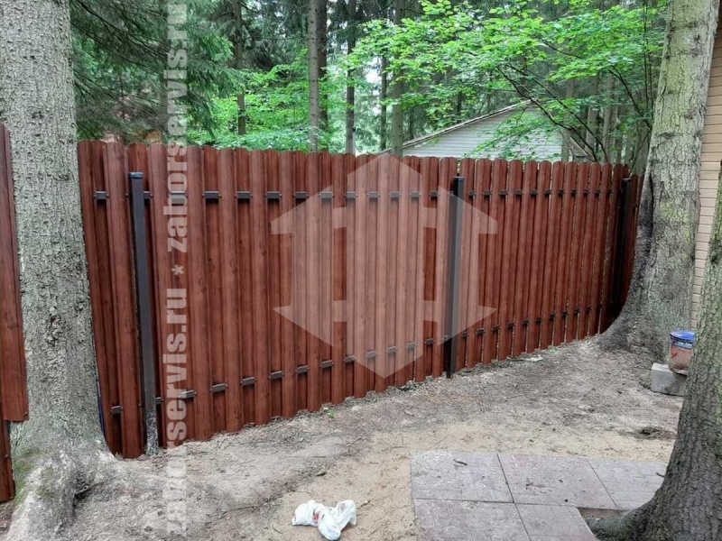 Забор из металлического штакетника на фундаменте под дерево